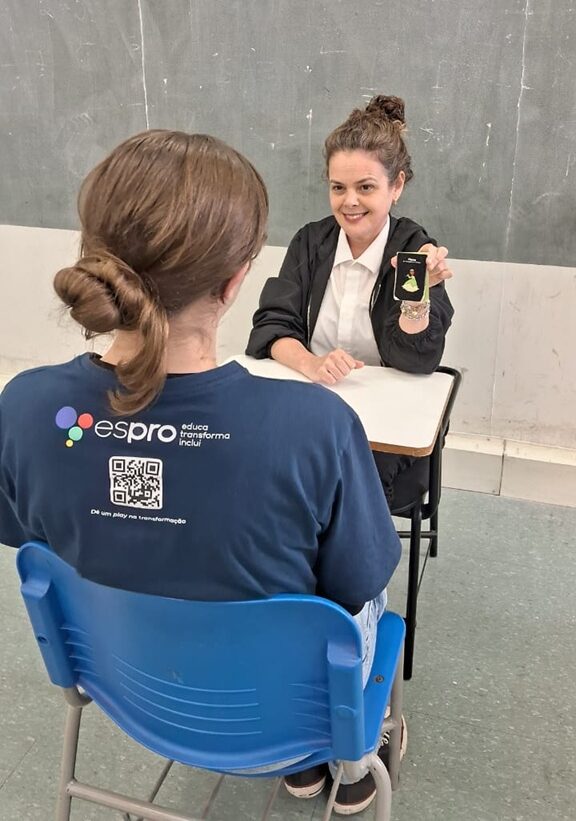 JOVEM SENTADA NA FRENTE DA INSTRUTORA COM O JOGO A SUA FRENTE